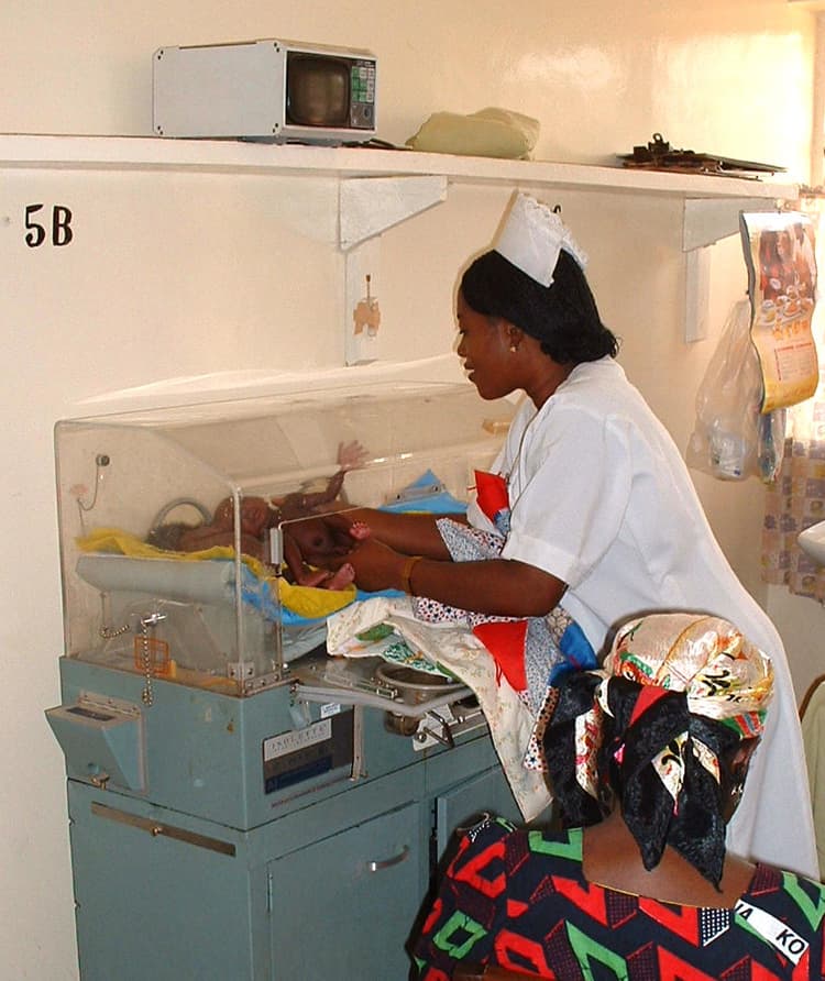 A pediatric nurse checking recently born triplets in an incubator at ECWA Evangel Hospital, Jos, Nigeria